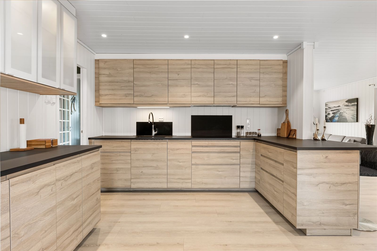 Cuisine sur mesure en bois clair avec plan de travail sombre, réalisée en atelier