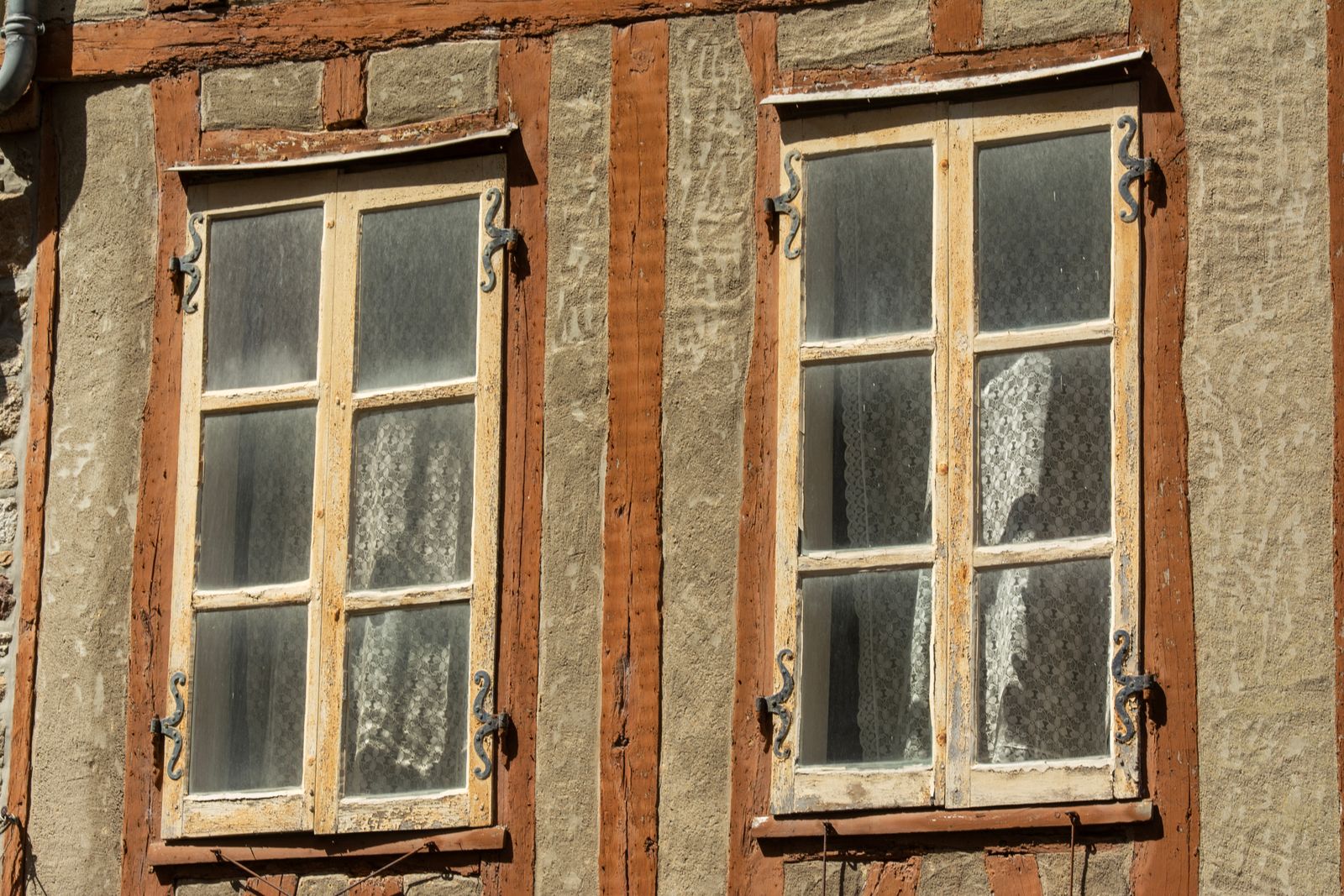 Anciennes fenêtres à croisillons en bois sur une façade, avant rénovation